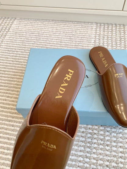 MULES IN BROWN GLOSSY SHEEPSKIN GOLD LETTERING LOGO