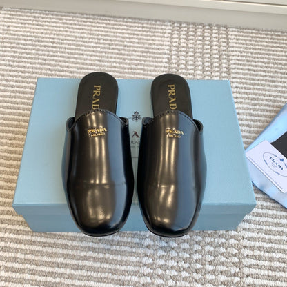 MULES IN BLACK GLOSSY SHEEPSKIN GOLD LETTERING LOGO