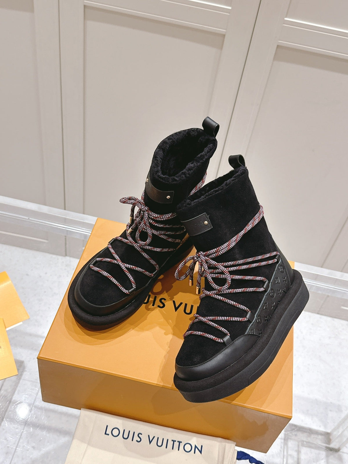 ASPEN PLATFORM ANKLE BOOT IN BLACK MONOGRAM DEBOSSED SUEDE AND SHEARLING