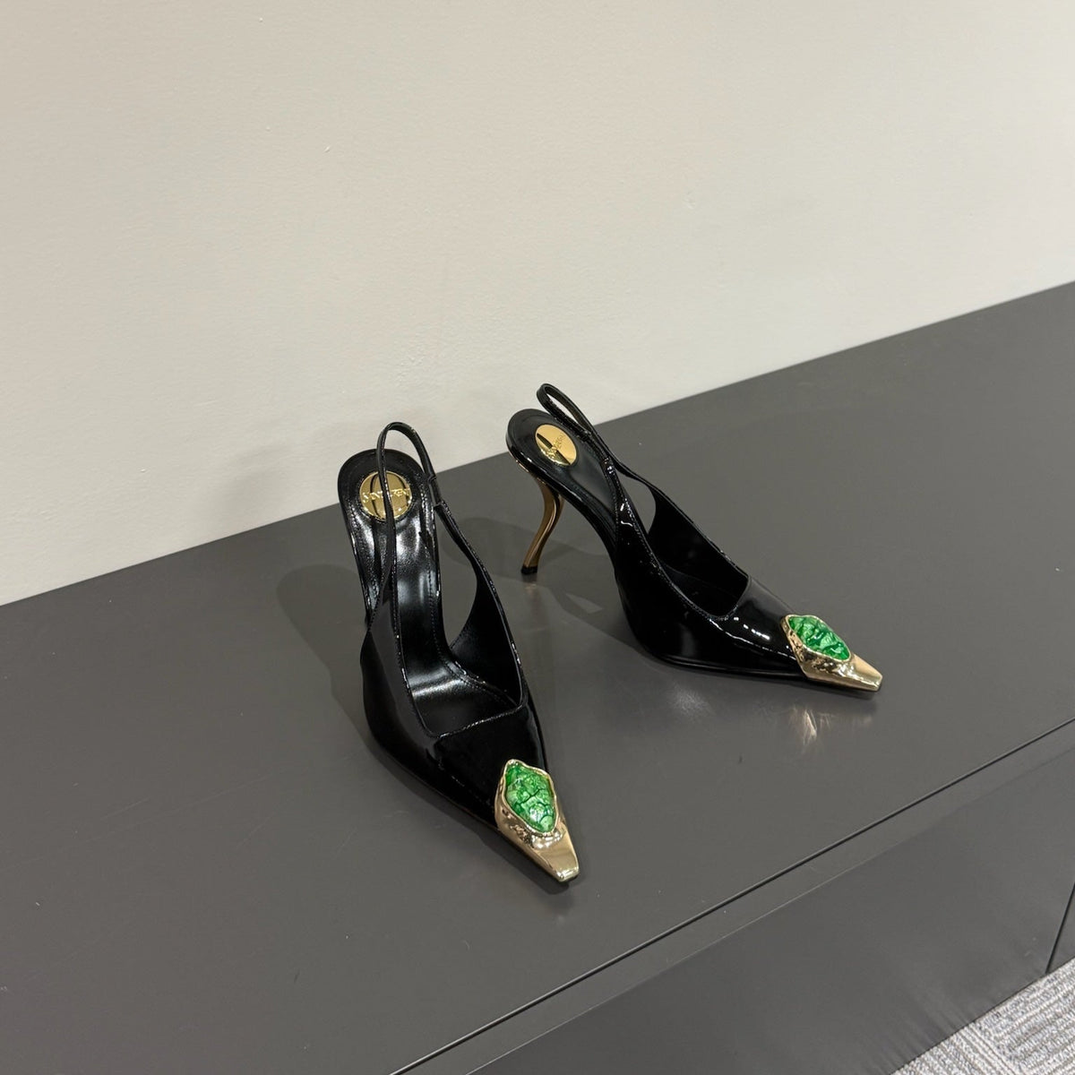 GREEN GEM-STUDDED SLINGBACK PUMPS IN BLACK PATENT CALFSKIN