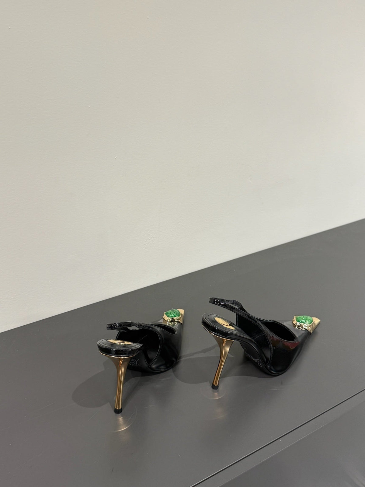 GREEN GEM-STUDDED SLINGBACK PUMPS IN BLACK PATENT CALFSKIN