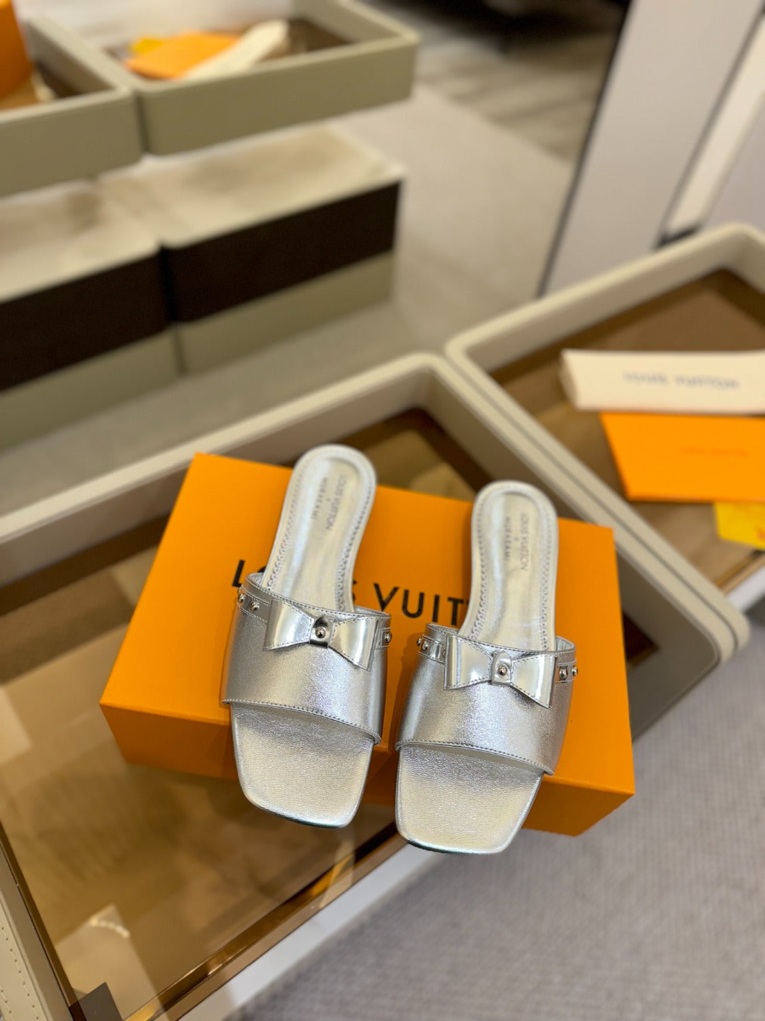 LV X TM 6AM FLAT MULE IN SILVER CALFSKIN